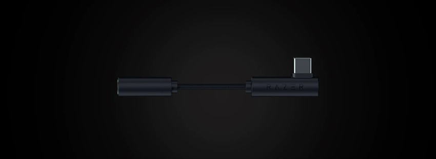 A black Razer-branded USB-C to 3.5mm audio jack adapter on a dark background.