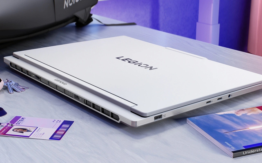 桌上放置有已合上的白色 Legion 7i Gen 10，旁邊是學生證和一本 STEM 課本。