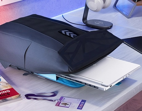 Legion 7i Gen 10 筆記型電腦的一部分已經放入書桌上的背囊中，旁邊是上學用品。