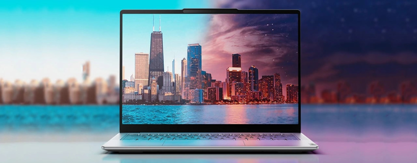 Front-facing view of open Luna Grey Yoga Slim 7i Gen 9 laptop with a picture of a skyline on the display