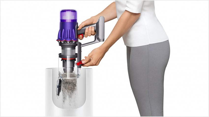 女性將Dyson Digital Slim輕量無線吸塵機中的塵垢清空至垃圾筒中