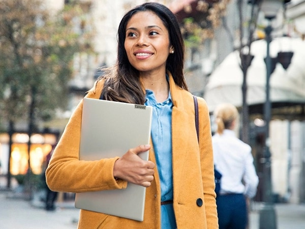 A woman carrying a Lenovo IdeaPad Slim 5i Gen 9 (14