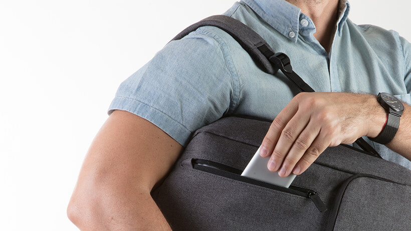 男士把 Belkin USB-C™ 多媒體集線器放進他的背包